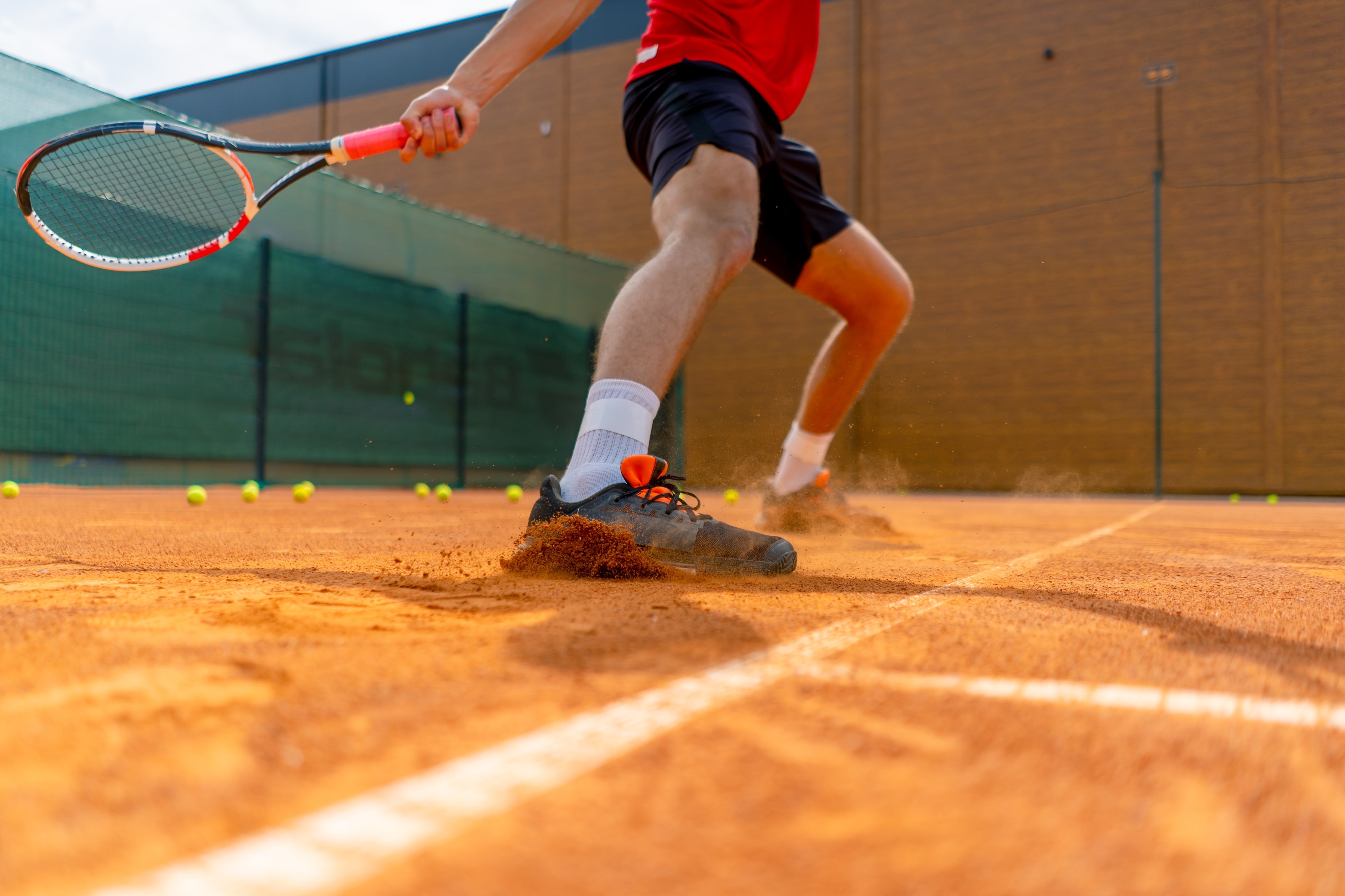 A tennis player is swinging his racket.